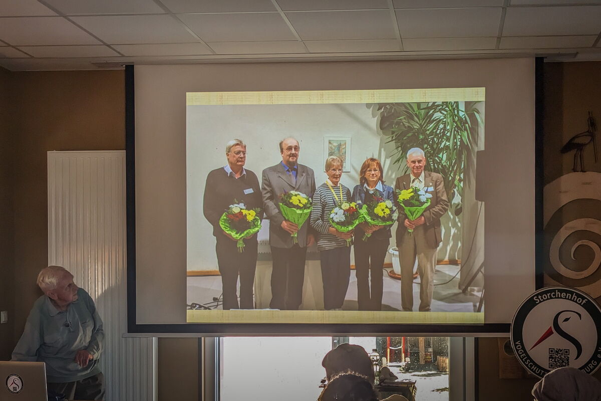 auf der Leinwand ein Foto mit den 5 Vorstandsmitgliedern, die 2005 gewählt wurden